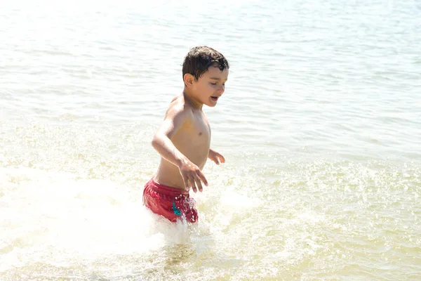 Menino descansando na praia — Fotografia de Stock