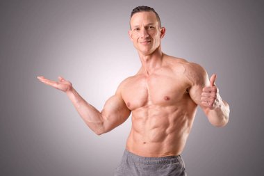 gri bir arka plan üzerinde poz uygun kaslı adam izole