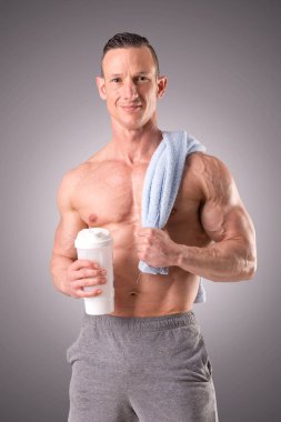 gri bir arka plan üzerinde poz uygun kaslı adam izole