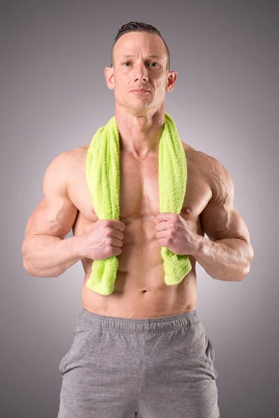 Fit muscular man posing isolated on a grey background — Stock Photo, Image