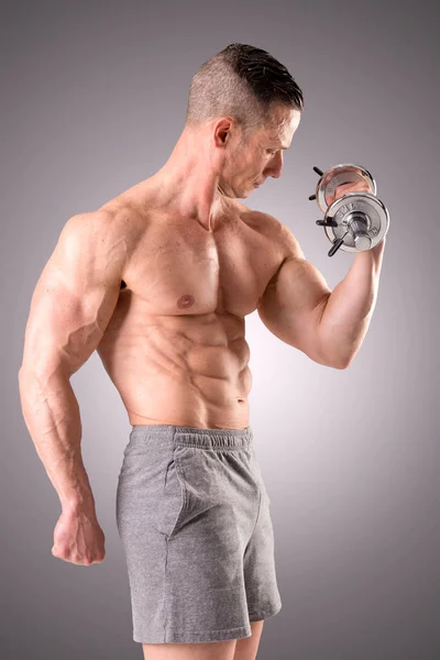 Ajuste homem muscular posando isolado em um fundo cinza — Fotografia de Stock