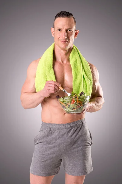 Homem muscular segurando salada — Fotografia de Stock
