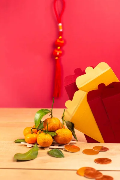 Çin Yeni Yıl Festivali dekorasyonu. Çin zarfı, portakal, yaprak, kırmızı paket, ahşap arka planda. (Zarftaki Metin Mutlu Yıllar ve Mutluluk anlamına gelir)