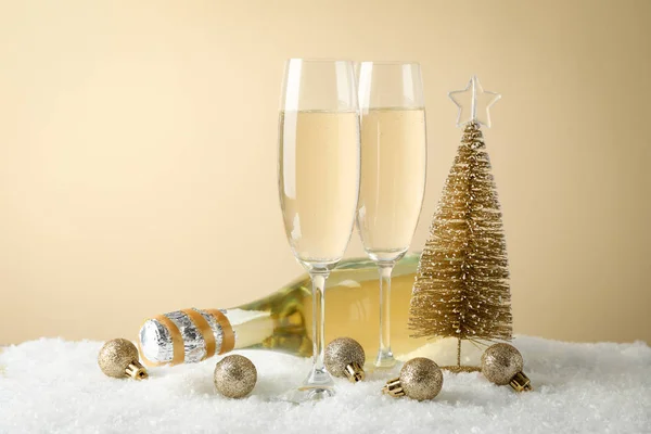 Baubles, verres à champagne et bouteille sur fond beige , — Photo