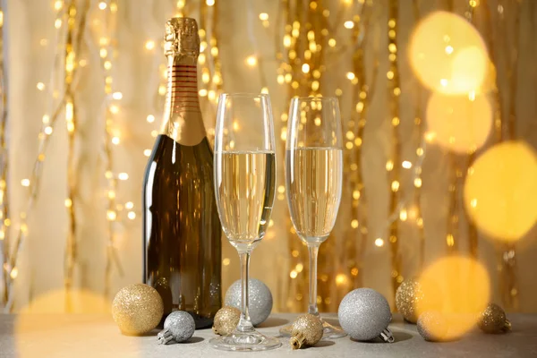 Grannlåt, champagneglas och flaska mot dekorerad backgrou — Stockfoto