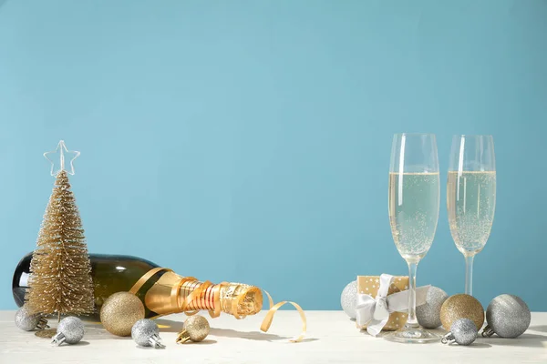 Bombki, kieliszki szampana i butelka na niebieskim tle, s — Zdjęcie stockowe
