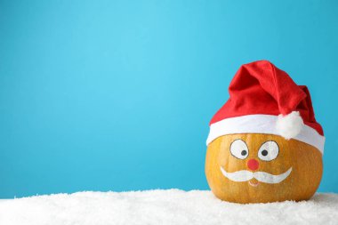 Bıyıklı balkabağı ve mavi arka planda kırmızı Noel Baba şapkası, anlaşıldı.