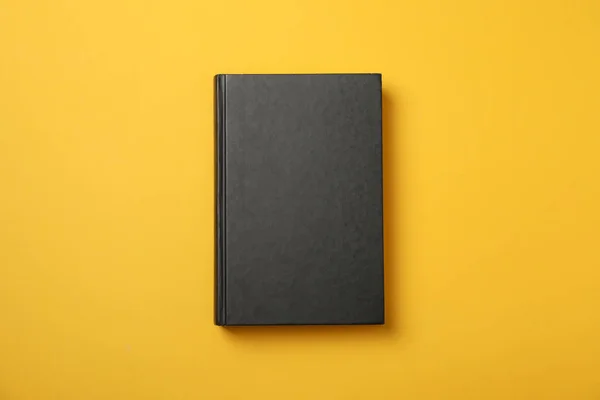 Černá kniha na žlutém pozadí, prostor pro text — Stock fotografie