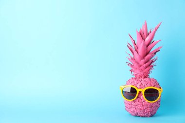 Mavi arka planda güneş gözlüklü pembe ananas, boşluk