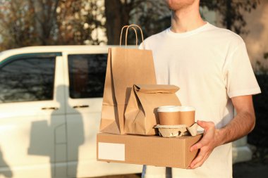 \ ourier boş kutu, kahve fincanları ve kağıt paketleri karşı tutar