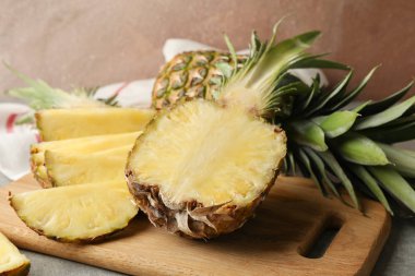 Gri arkaplanda kesme tahtası ve ananas, kapatın