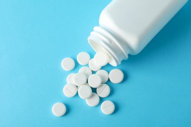 Mavi arka planda farklı haplar içeren şişe, metin için boşluk
