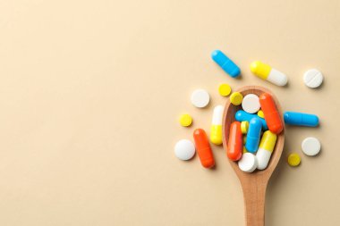 Bej arka planda kaşık ve haplar, metin için boşluk