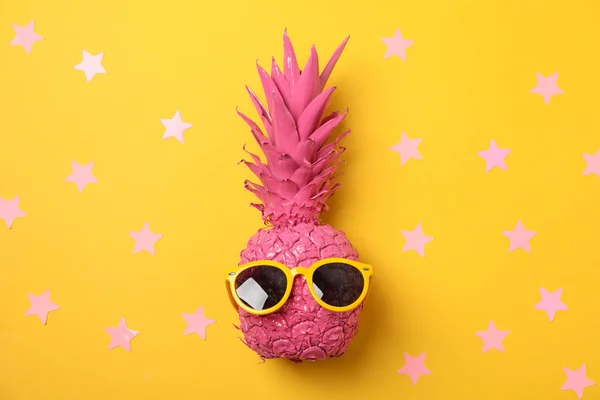 Ananas rosa dipinto con occhiali da sole su dorso giallo decorato — Foto Stock
