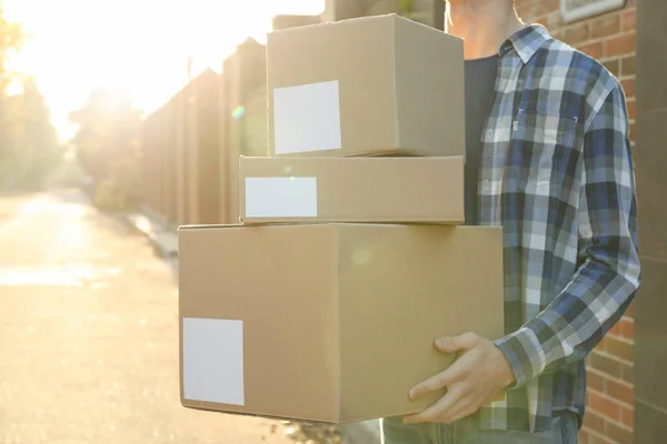 Man in shirt houdt lege dozen buiten, ruimte voor tekst — Stockfoto