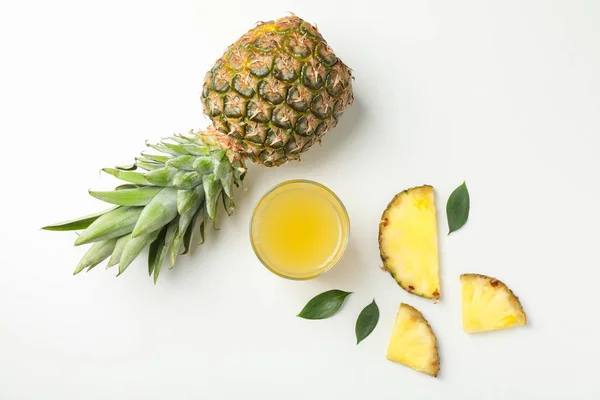 Composizione con ananas, fette e bicchiere di succo su b bianco — Foto Stock