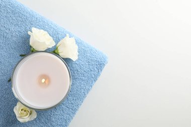 Beyaz arka planda havlu, mum ve Eustoma, üst manzara. Spa dolandırıcılığı