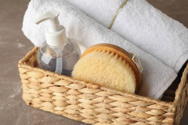 Gri arka planda vücut bakım aksesuarları olan sepet, kapat