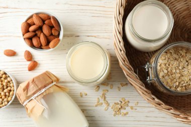 Beyaz ahşap arka planda farklı tipte sütler. 