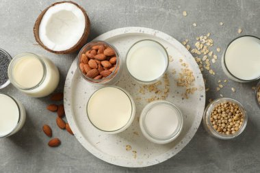 Gri arka planda farklı tipte süt ve şişe ve cam kaplıca