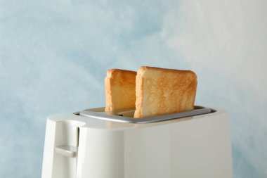 Mavi arkaplanda ekmek dilimleri olan tost makinesi, metin için boşluk