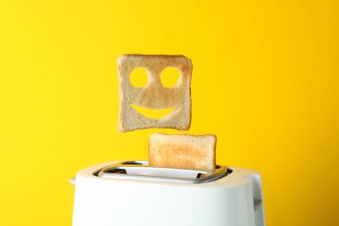 Tost makinesi ve tost makinesi, sarı arka planda gülen surat, boşluk...