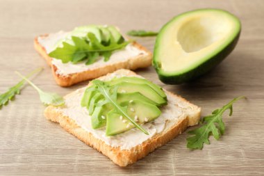 Tereyağlı tost, avokado, roka ve susamlı ahşap sırt üstü.