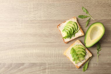 Tereyağlı tost, avokado, roka ve susamlı ahşap sırt üstü.