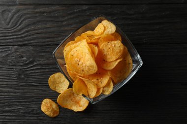 Tahta arka planda bir yerde patates cipsi, mesaj için yer. Buraya...