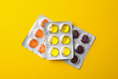 Sarı arka planda su toplayan şeker paketleri, üst görünüm