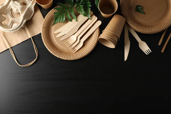Composição com eco - utensílios de mesa amigáveis e planta em bac preto — Fotografia de Stock
