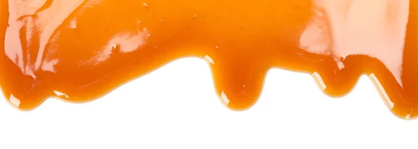 Fluindo molho de caramelo isolado no fundo branco, close-up — Fotografia de Stock