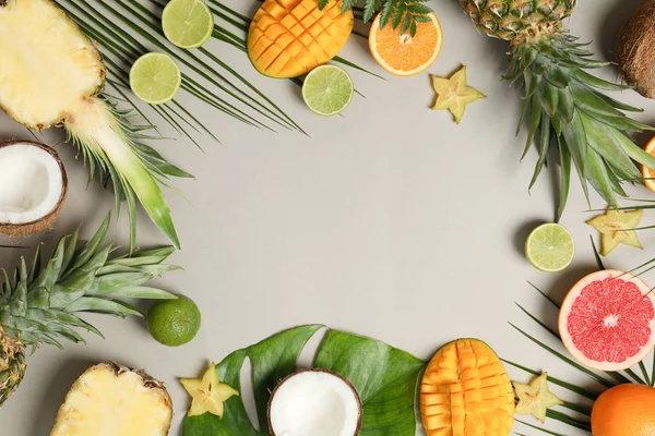 Composición con frutas exóticas y hojas de palma sobre fondo gris — Foto de Stock