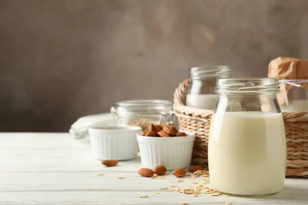 Garrafa de leite de aveia, cesta com copos de diferentes tipos mil — Fotografia de Stock