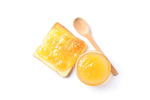 Rostat bröd med aprikos sylt, skål och sked isolerad på vit bakgrund — Stockfoto