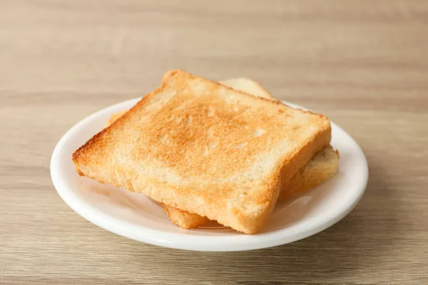 Teller mit Toasts auf Holzuntergrund, Nahaufnahme — Stockfoto