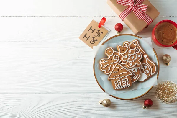 Plate with Christmas cookies, toys and coffee on white wooden ba — Stock Photo, Image