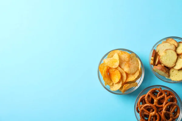 Bolachas, batatas fritas. Petiscos de cerveja no fundo azul, espaço para texto . — Fotografia de Stock