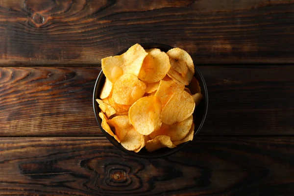 Potatischips. Öl snacks på trä bakgrund, utrymme för text. — Stockfoto