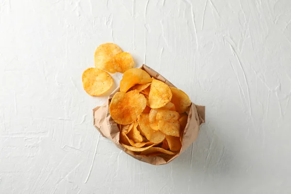Bolsa de papel de papas fritas sobre fondo de madera blanca, espacio para — Foto de Stock