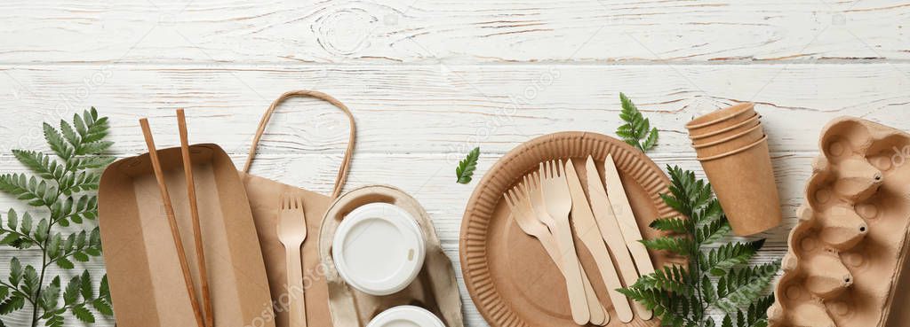Concept with eco - friendly tableware and plant on wooden backgr