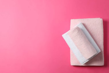 Pembe arkaplanda katlanmış havlular, metin için üst görünüm ve boşluk