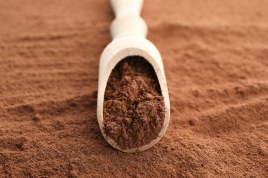 Tahta kepçe ve kakao tozu arka planı, kapatın.