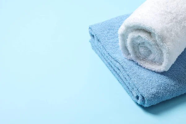 Folded towels on blue background, close up and space for text — Stock Photo, Image