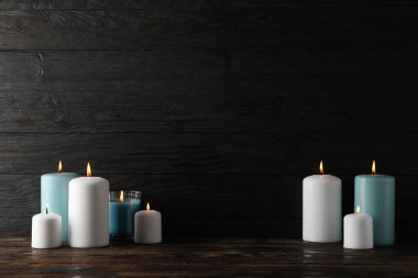 Ahşap arkaplanda farklı yanan mumlar, metin için yer