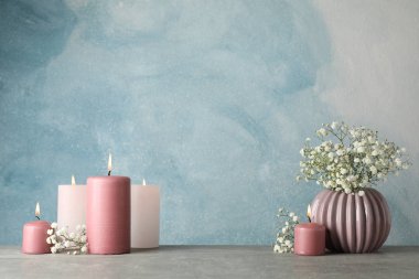 Bir grup yanan mum ve çiçek mavi arka planda, spa