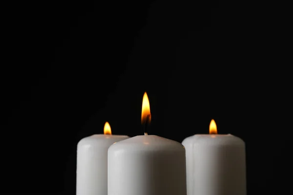 Zářící svíčky na černém pozadí, prostor pro text — Stock fotografie