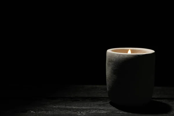 Lilin pada meja kayu terhadap latar belakang hitam, spasi untuk teks — Stok Foto