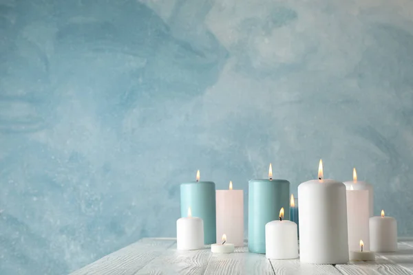 Различные горящие свечи на голубом фоне, пространство для текса — стоковое фото