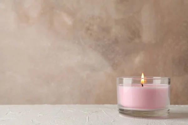 Różowa świeca w szklanym słoiku na białym stole, miejsce na tekst — Zdjęcie stockowe